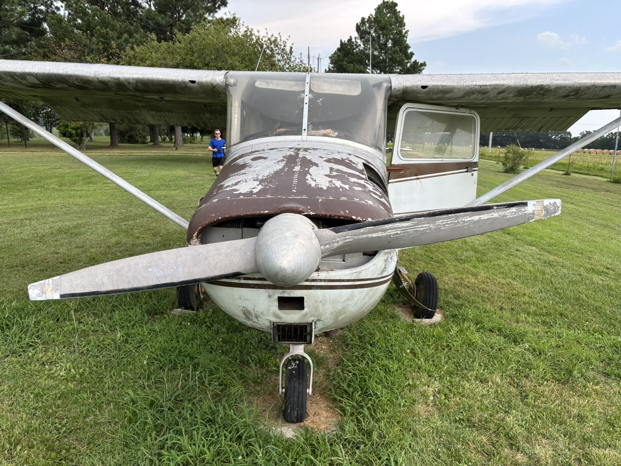 Front view of N8777B showing its weathered cowling, fixed landing gear, and two-blade propeller.