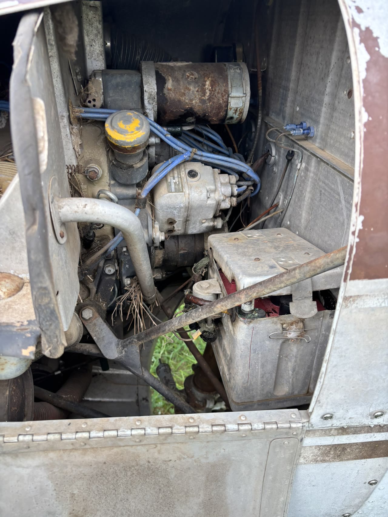 Open engine compartment of N8777B documenting the engine and surrounding components as acquired.