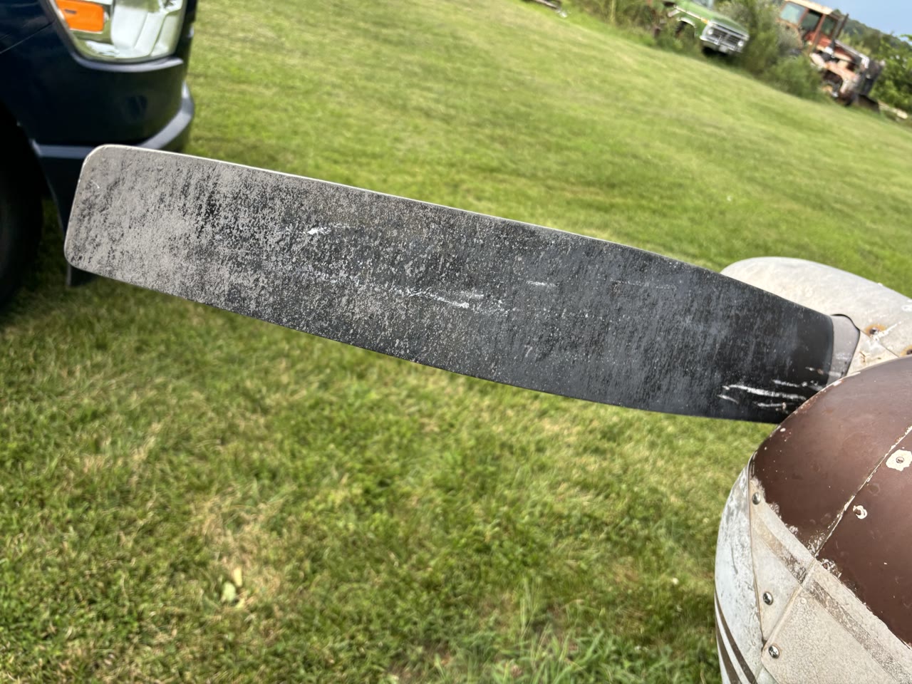 Close view along a weathered propeller blade on N8777B during the initial inspection.