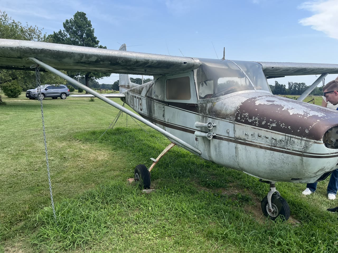 The weathered Cessna 172 N8777B, The Old Scotchman, standing on grass at the beginning of its restoration.