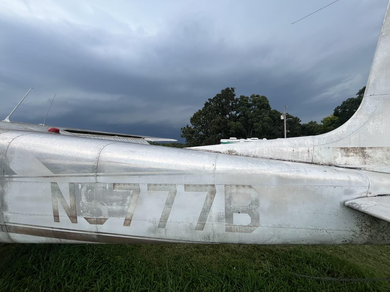 Close view of the faded N8777B registration marking on the rear fuselage.