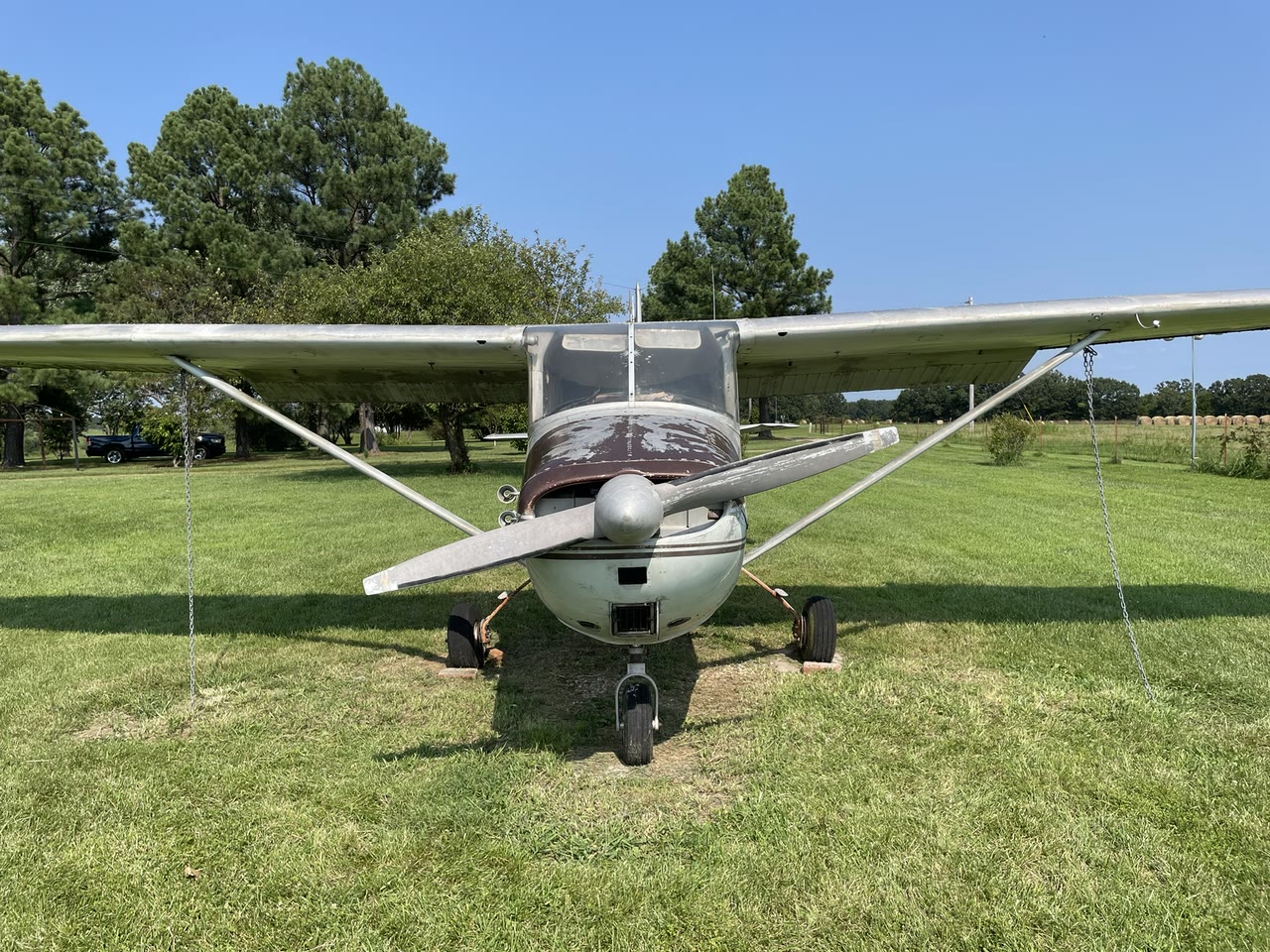 Centered front view of N8777B after initial professional cleaning, showing the propeller, cowling, wings, and fixed landing gear.